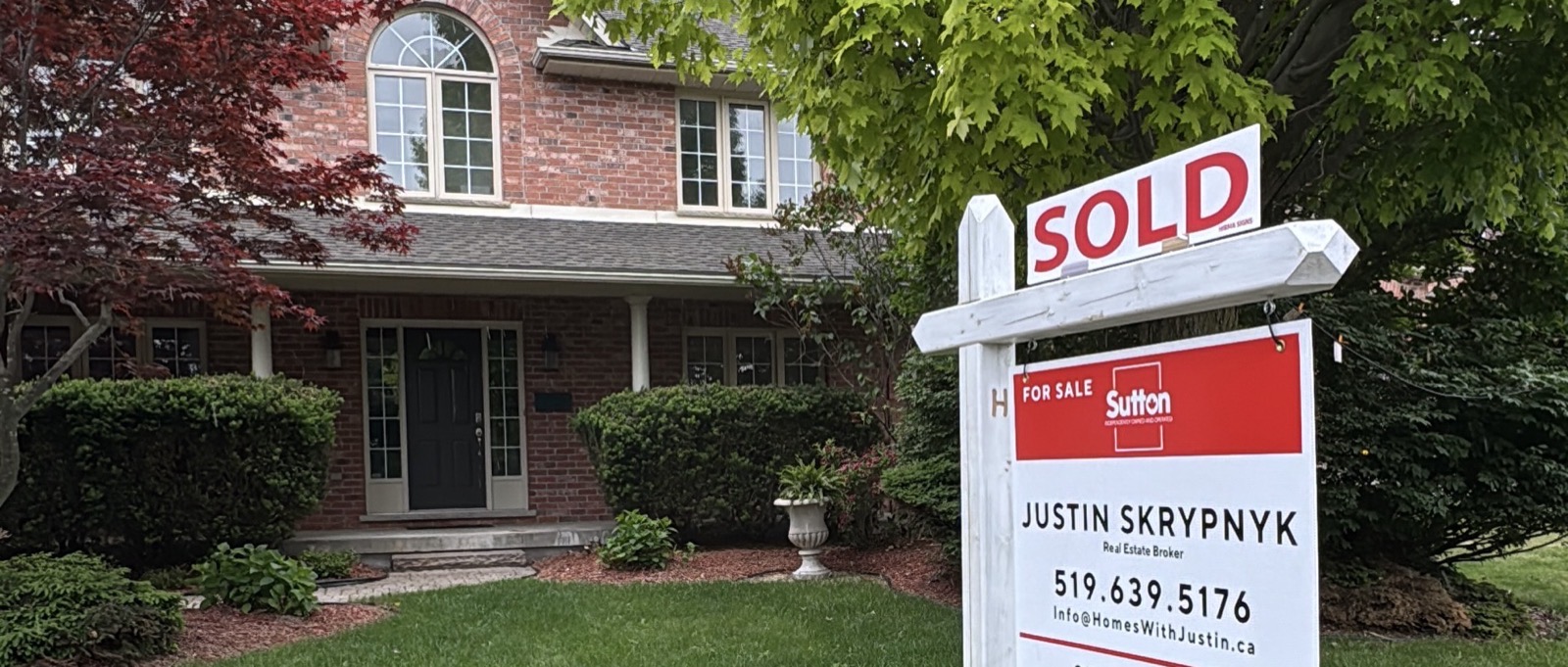 A SOLD sign in front of a London Ontario home, representing closing day on a real estate transaction