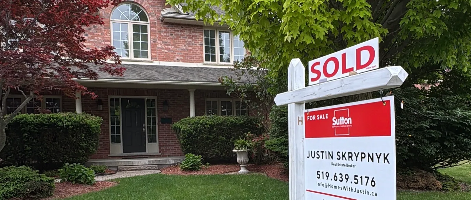 A SOLD sign in front of a London Ontario home, representing closing day on a real estate transaction